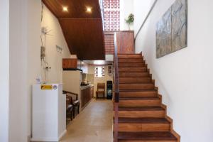 a staircase in a house with wooden floors and a kitchen at Urbanview Hotel Arta Guna Casa in Kerobokan