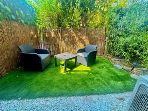 two chairs and a table in front of a fence at Appartement Love Room/Jacuzzi in Toulouse