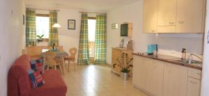 eine Küche und ein Wohnzimmer mit Sofa und Tisch in der Unterkunft Ferienwohnung Matzhof in Welschnofen