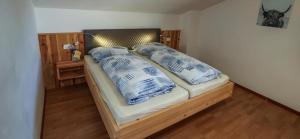 ein Bett mit Kissen darauf in einem Zimmer in der Unterkunft Ferienwohnung Matzhof in Welschnofen