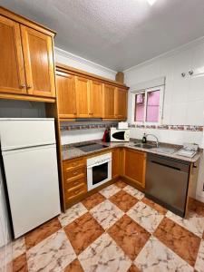 a kitchen with wooden cabinets and a white refrigerator at Lima in Orihuela Costa
