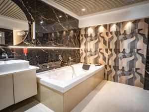 a bathroom with a tub and a sink at Hotel Spencer-Navi Mumbai in Navi Mumbai