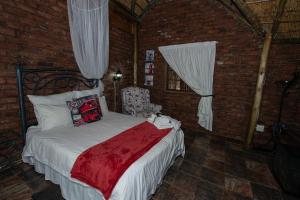 a bedroom with a bed with a red blanket at Sundown Lodge and Confrence in Aliwal North