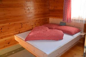 a bedroom with two beds in a wooden room at Ferienhaus Fritzensee in Bartholomäberg