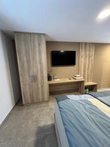 a bedroom with a bed and a flat screen tv at Korantov Hram in Bukovci