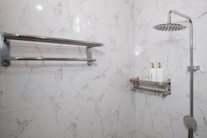 a bathroom with a white marble wall with a shower at Urbanview Hotel Arta Guna Casa in Kerobokan +48 photos