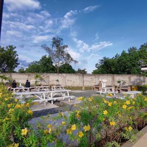 people sitting at picnic tables in a garden with flowers at Affordable Condo Unit in Saekyung Phase 3 in Suba
