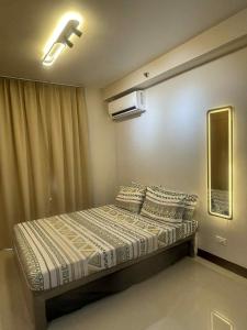a bedroom with a bed with pillows and a window at Affordable Condo Unit in Saekyung Phase 3 in Suba +13 photos