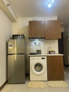 a kitchen with a washing machine and a refrigerator at Affordable Condo Unit in Saekyung Phase 3 in Suba