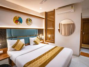 a hotel room with a bed and a mirror at Hotel Spencer-Navi Mumbai in Navi Mumbai