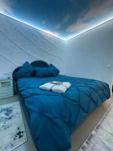 a bed with a blue comforter in a room at Cloud Express in Petroşani