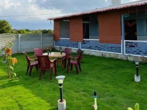 a patio with a table and chairs on a yard at Vara Farm in Kanakapura