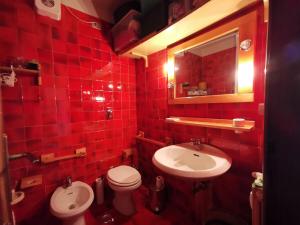 a red tiled bathroom with a toilet and a sink at Casa Verde in Sestriere +21 photos