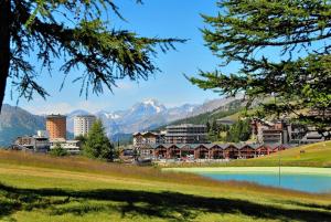 a town with a lake and mountains in the background at Casa Verde in Sestriere