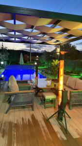 a deck with benches and a swimming pool at night at Akcavillagarden in İzmir +3 photos