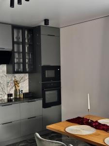 a kitchen with a wooden table and a stove top oven at Grey House in Slavske