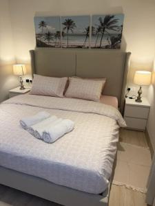 a bedroom with a bed with two towels on it at Sunset Hawana in Salalah +16 photos