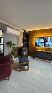a living room with a fireplace and a tv at Akcavillagarden in İzmir