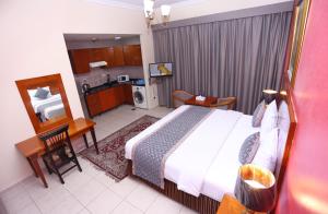 a bedroom with a large bed and a kitchen at Icon Hotel Apartments in Dubai