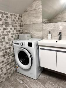 a bathroom with a washing machine and a sink at Grey House in Slavske