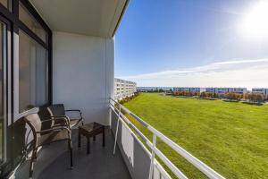 a balcony with chairs and a large field of grass at IFA Yachthafen Fehmarn in Fehmarn