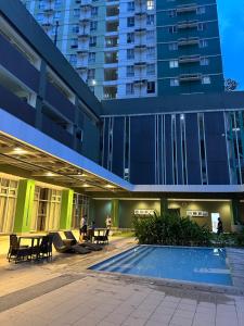 a building with a swimming pool in front of a building at Modern Studio IT Park Fast Wi-Fi, Pool,Netflix in Sampong