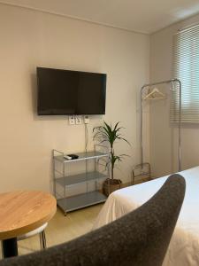 a bedroom with a flat screen tv on the wall at Yellow stay in Bucheon