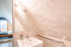 a bathroom with a sink and a mirror at Üveghuta Vendégház in Vágáshuta +45 photos