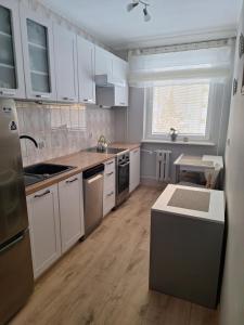 a large kitchen with white cabinets and a sink at Apartament Cichy Zakątek in Ruciane-Nida
