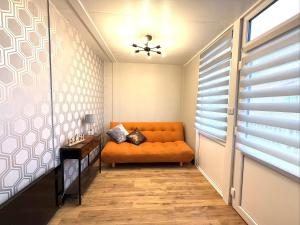 an orange couch in a room with a window at Bayside in Bridlington