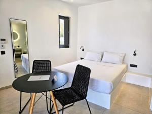 a bedroom with a bed and a table and chairs at myLithos Suites in Monolithos +92 photos