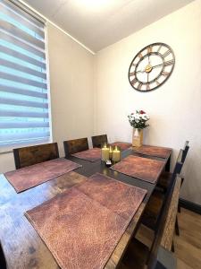 a dining room with a table with a clock on the wall at Bayside in Bridlington