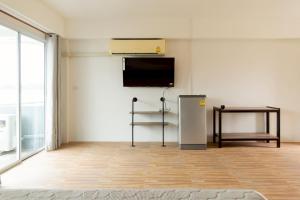 a room with a refrigerator and a tv on the wall at อิงน้ำ เลควิว in Ban Hua Phrong