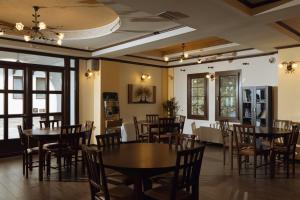 a dining room with tables and chairs and windows at Agnanti Hotel in Velventós