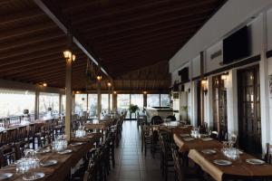 a dining room with wooden tables and chairs at Agnanti Hotel in Velventós