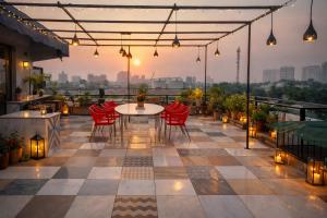 a patio with a table and chairs on a balcony at Hotel Stiltstay in Greater Noida