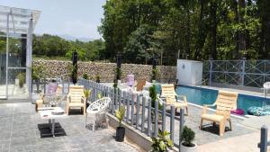 a patio with chairs and a fence next to a pool at leisure valley resort in Jhājra
