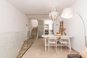 a dining room with a white table and chairs at Apartamento Sa Punta II in Portocolom