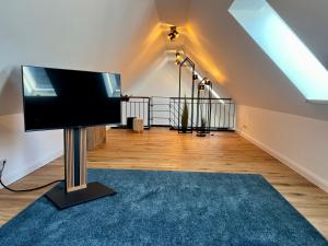 a living room with a flat screen tv on a pole at Pidder-Lyng Apartment 11 in Böhl