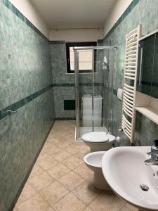 ein Badezimmer mit zwei Waschbecken, Dusche und Toilette in der Unterkunft Casa Cousteau in Policoro