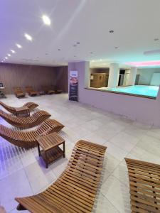 una grande stanza con sedie e una piscina di Hotel Verdeneve a Opi