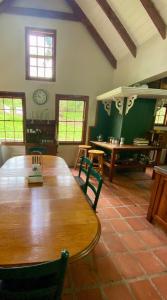 a dining room with a wooden table and chairs at Stoneygate Farm in Wakkerstroom