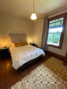 a bedroom with a white bed and a window at Stoneygate Farm in Wakkerstroom