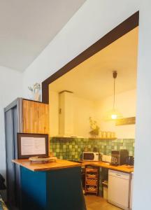 a kitchen with a desk with a computer on it at L'Empire D'Essences Appartement in Valréas
