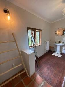 an attic room with stairs and a sink and a window at Stoneygate Farm in Wakkerstroom +11 photos