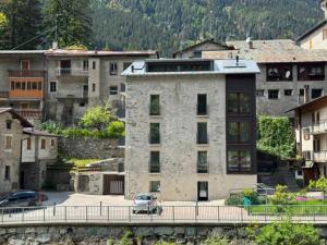 a building on a bridge over a river with buildings at Bormio365 Chalet in Valdisotto