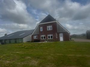 a large red brick house with a black roof at Bed en Bike Oudeschild in Oudeschild
