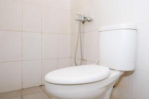 a white toilet in a bathroom with a shower at Lilis Cempaka Mas Guesthouse in Canggu +21 photos