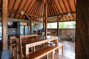 a dining room with wooden tables and chairs at Lilis Cempaka Mas Guesthouse in Canggu