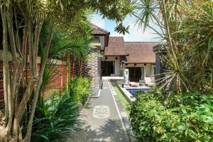 a house with a garden and a swimming pool at Lilis Cempaka Mas Guesthouse in Canggu